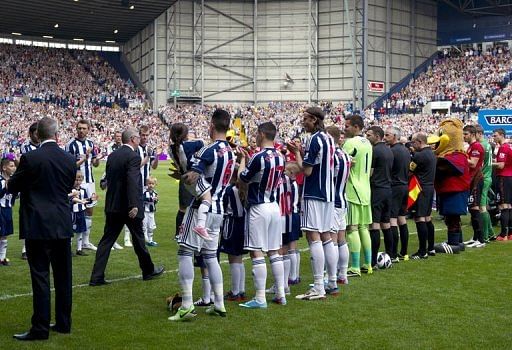 Alex Ferguson is greeted by players in West Bromwich on May 19, 2013